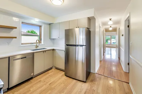 a kitchen with a refrigerator a sink and a stove top oven