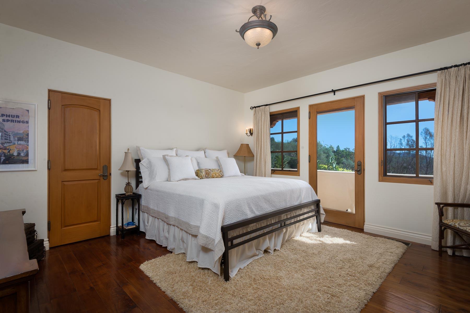 2220 Bella Vista Drive Montecito, CA 93108 - Photo 13 of 27 a spacious bedroom with a bed and wooden floor