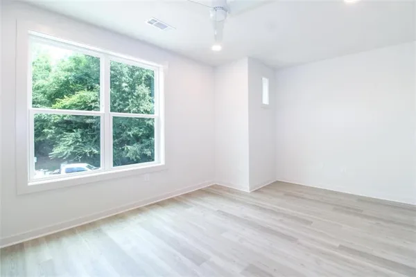 an empty room with wooden floor and windows