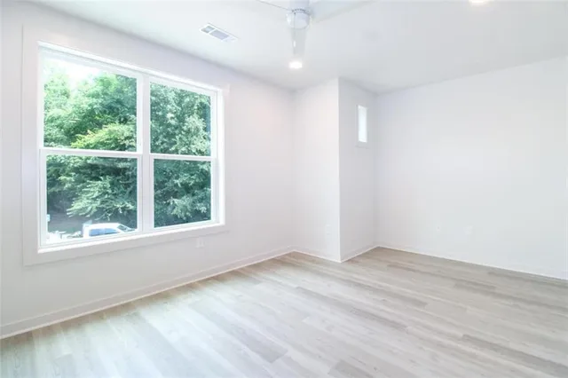 an empty room with wooden floor and windows