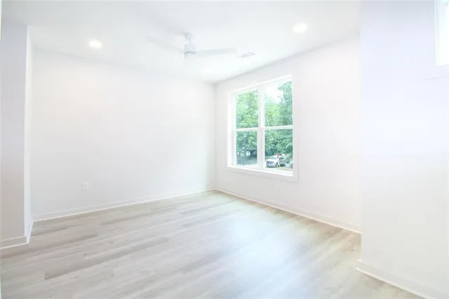 an empty room with wooden floor and windows