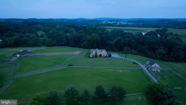 an aerial view of green landscape with trees houses and mountain view