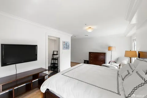 a bedroom with a bed and a flat screen tv