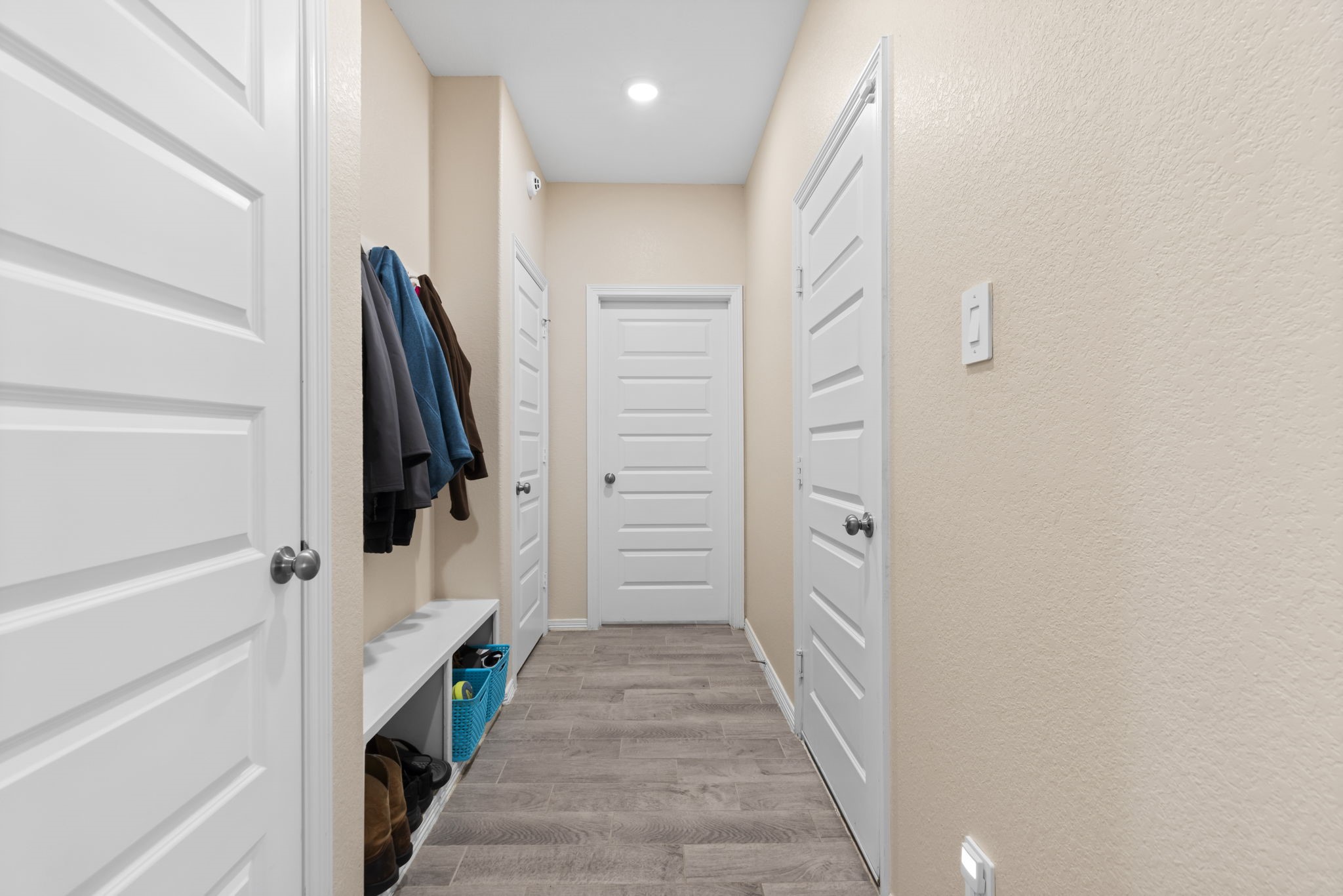 14499 Sunny Bend Way Conroe, TX 77303 - Photo 7 of 41 a hallway with white doors wooden floor and stairs