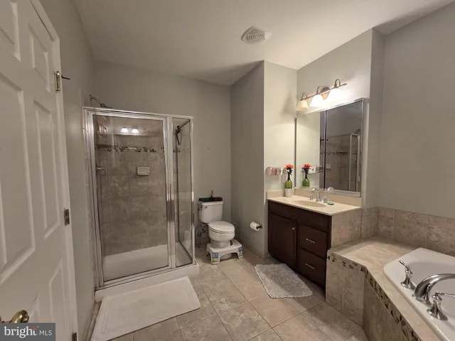 a bathroom with a granite countertop sink a toilet and shower