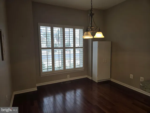 a room with wooden floor and windows