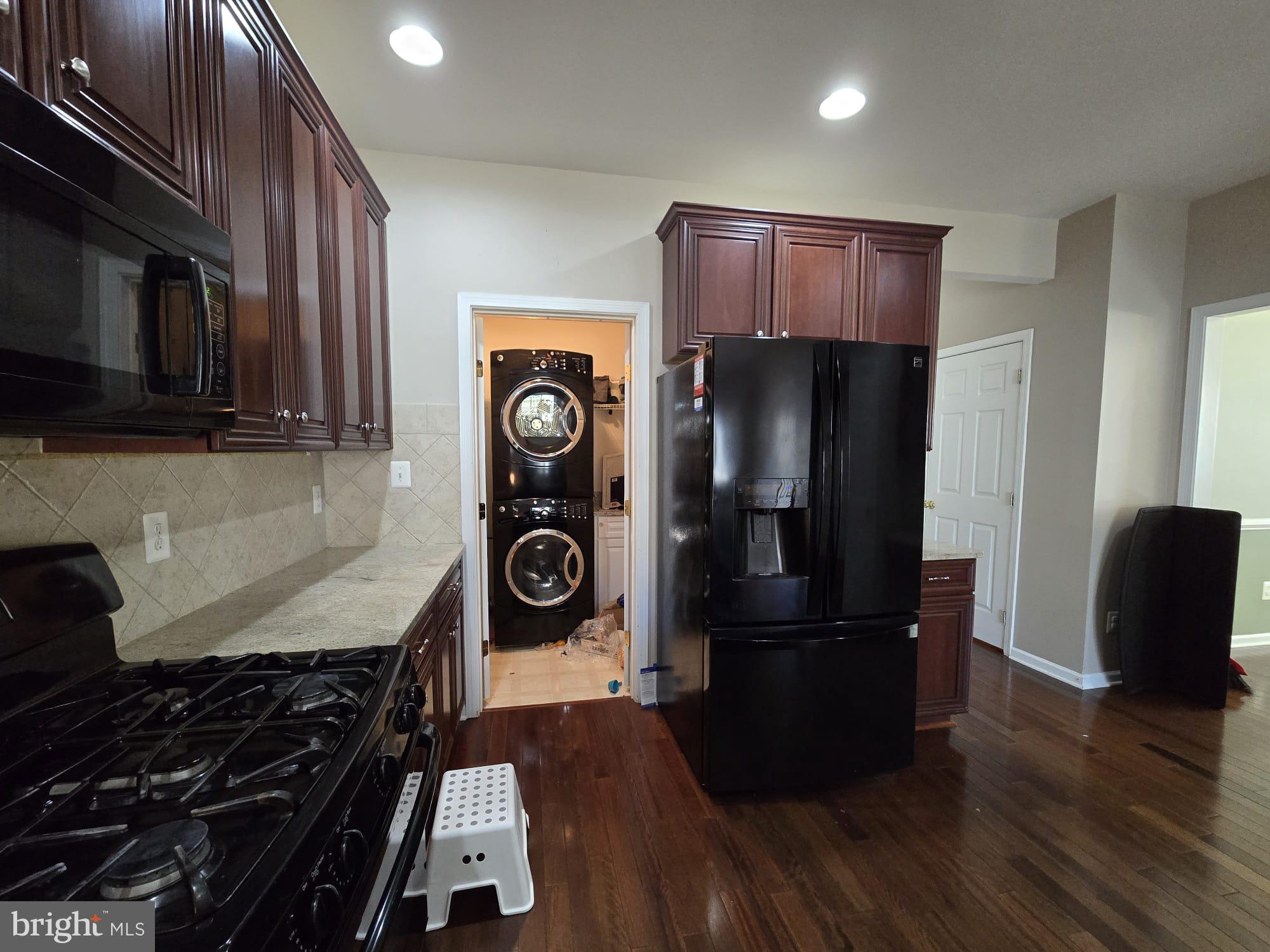 25170 Fortitude Terrace Chantilly, VA 20152 - Photo 20 of 50 a kitchen with a refrigerator a stove and wooden floor