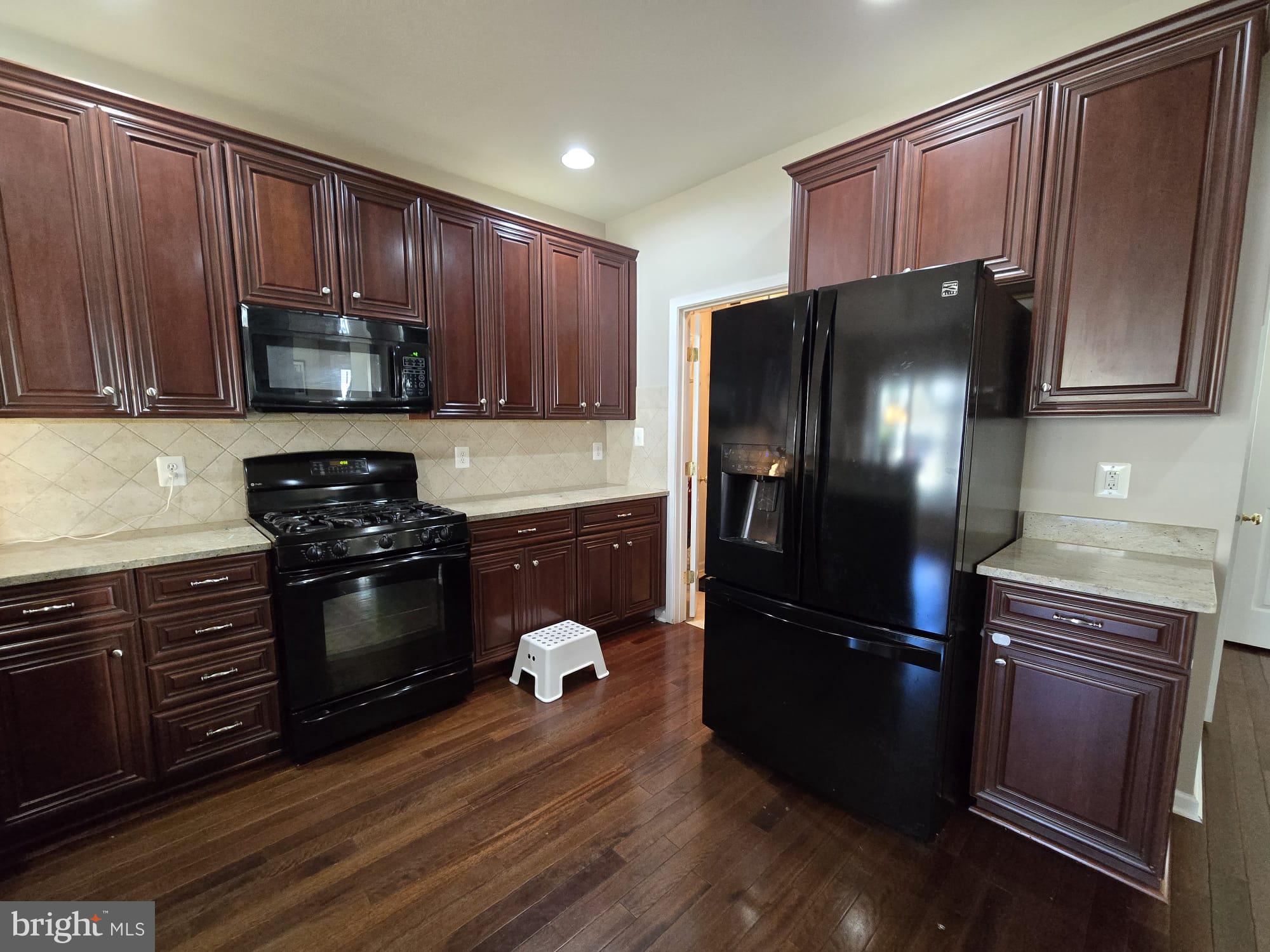 25170 Fortitude Terrace Chantilly, VA 20152 - Photo 21 of 50 a kitchen with granite countertop wooden cabinets and stainless steel appliances