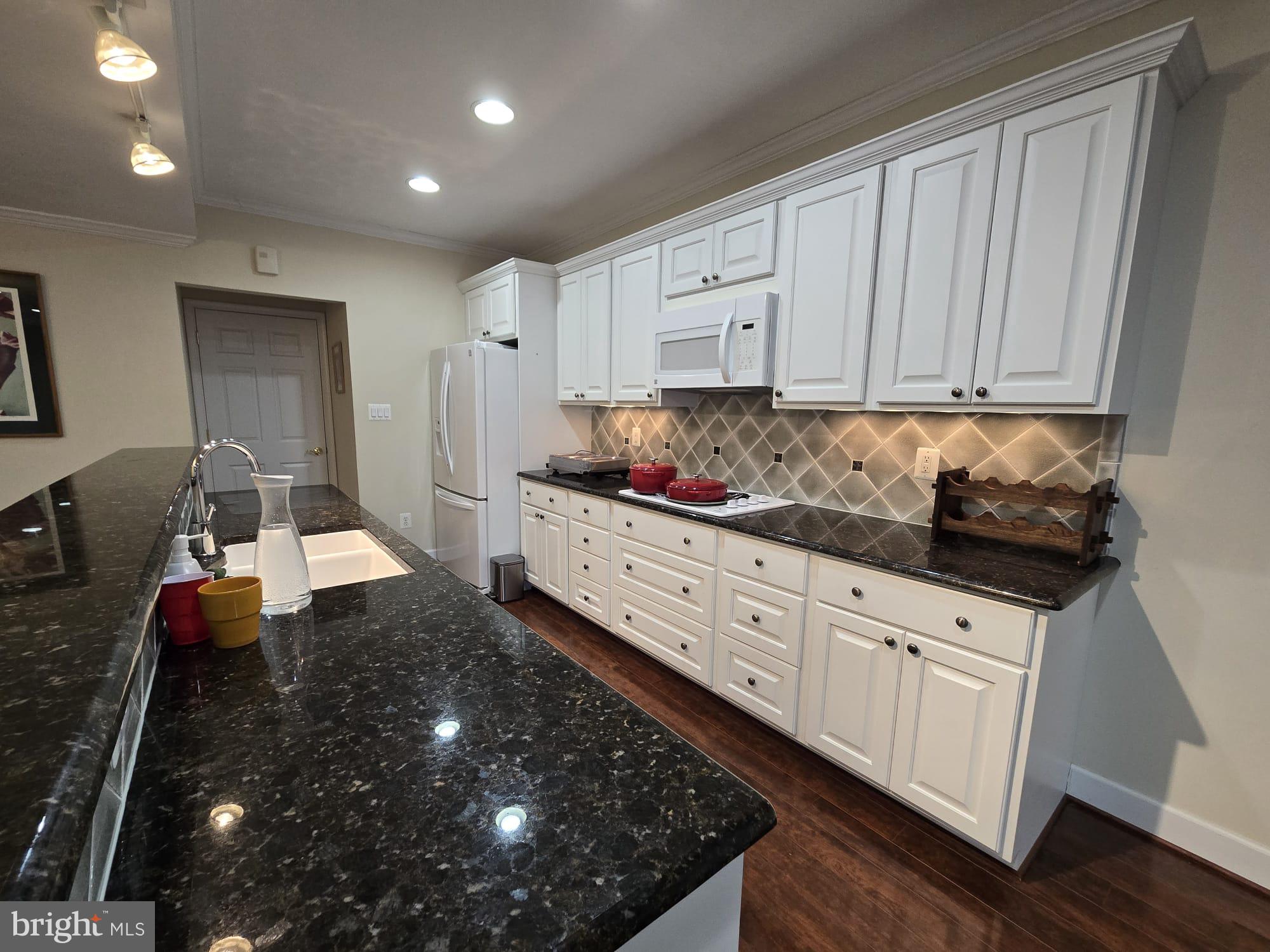 25170 Fortitude Terrace Chantilly, VA 20152 - Photo 38 of 50 a kitchen with granite countertop white cabinets and stainless steel appliances