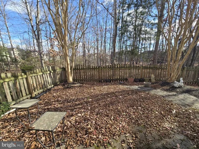 a view of a yard with wooden fence