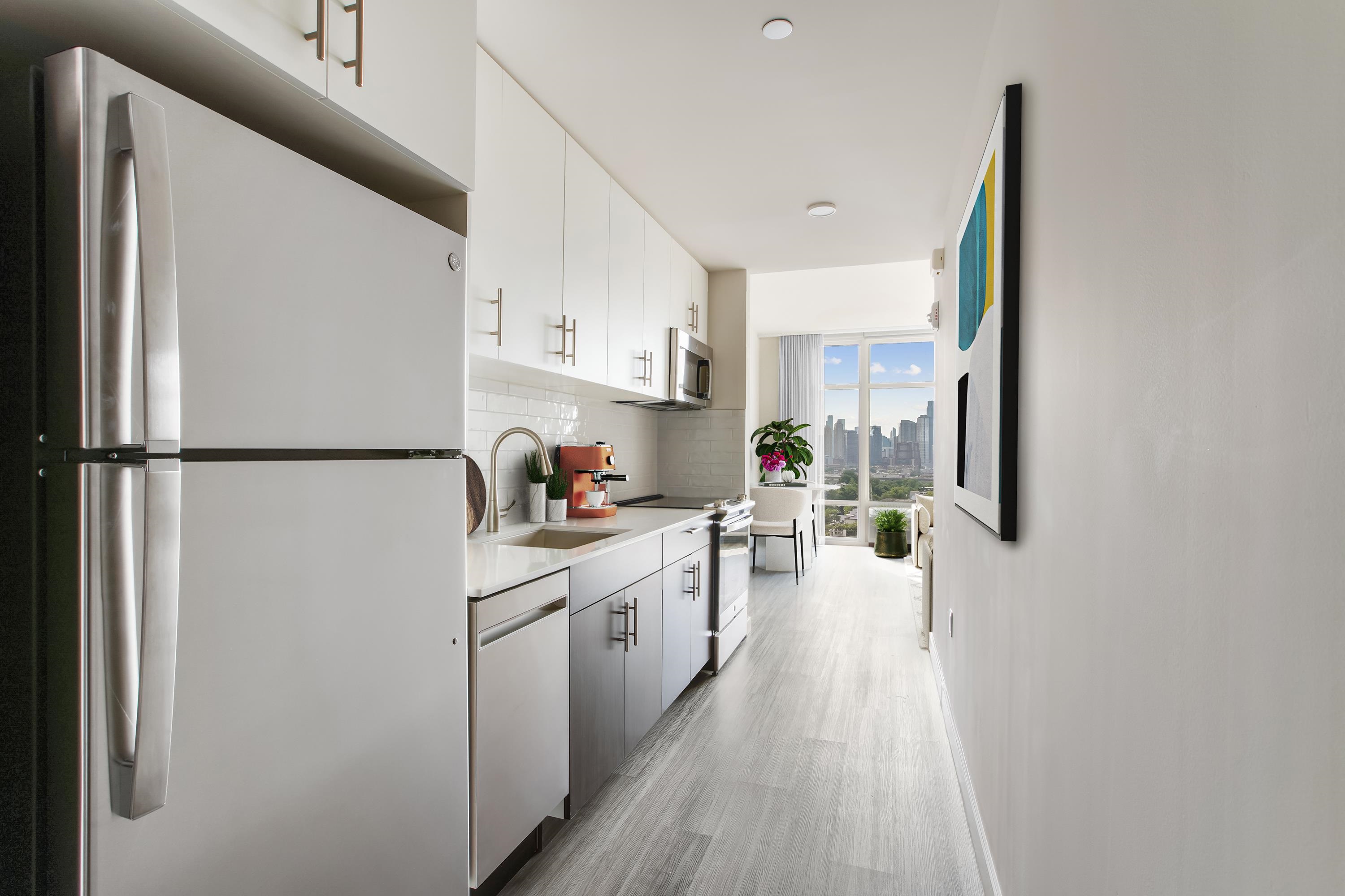 a kitchen with a refrigerator and white cabinets