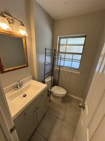 a bathroom with a sink mirror and toilet