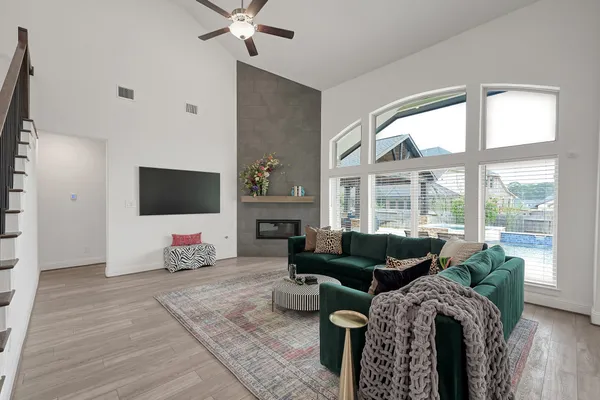 a living room with furniture a flat screen tv and a large window