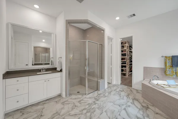 a bathroom with a granite countertop sink mirror bathtub and shower