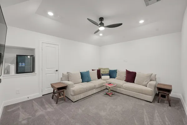 a living room with furniture and a ceiling fan