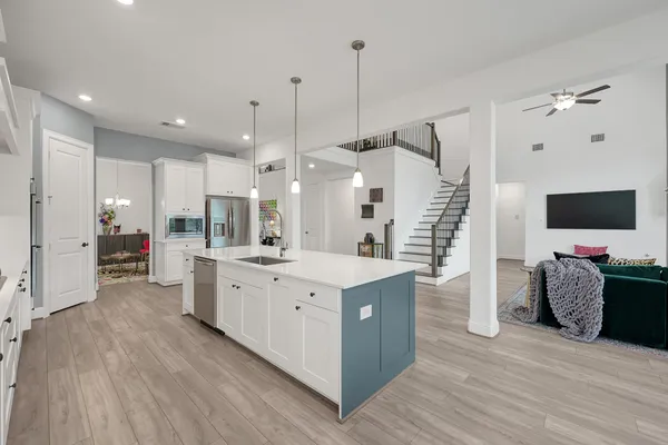 a large kitchen with stainless steel appliances kitchen island granite countertop a stove a sink and a wooden floors