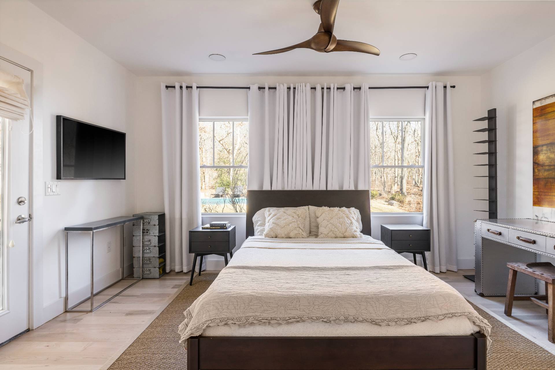 569 Toppings Path Sagaponack, NY 11962 - Photo 20 of 30 a spacious bedroom with a large bed a flat tv screen and a dresser