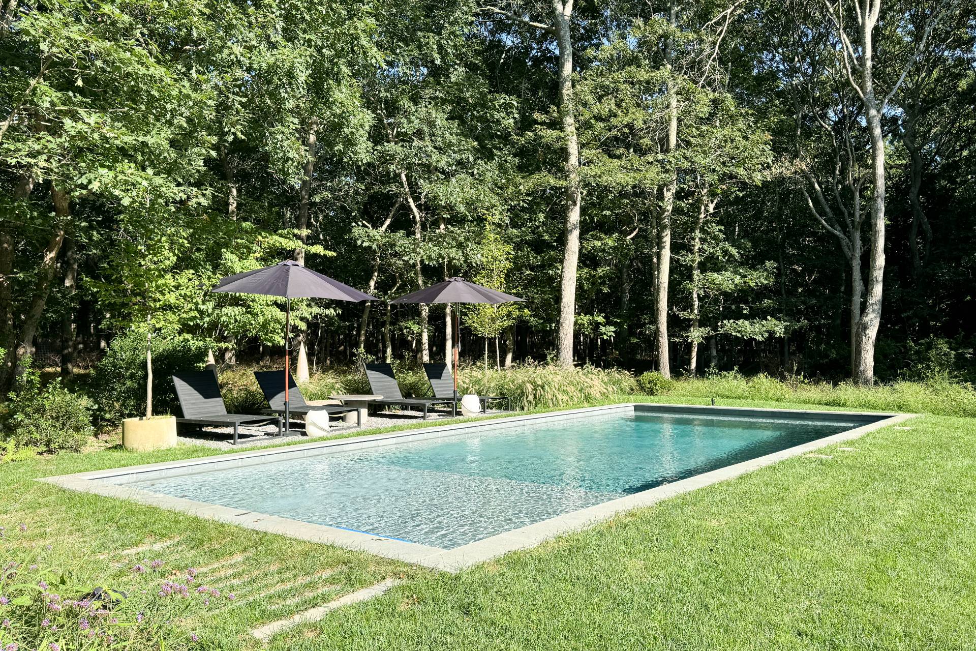 569 Toppings Path Sagaponack, NY 11962 - Photo 29 of 30 a view of swimming pool with lawn chairs and large trees