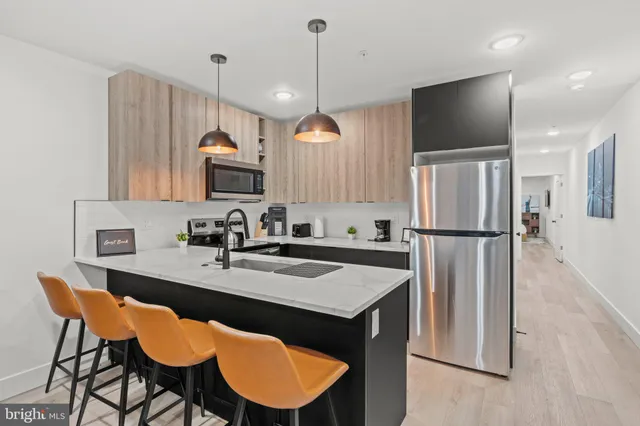 a kitchen with stainless steel appliances granite countertop a sink refrigerator and microwave