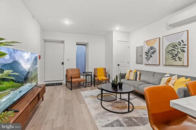 a living room with furniture a flat screen tv and a floor to ceiling window