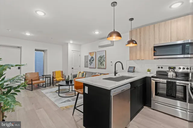 a kitchen with stainless steel appliances granite countertop a stove a sink dishwasher a dining table and chairs with wooden floor