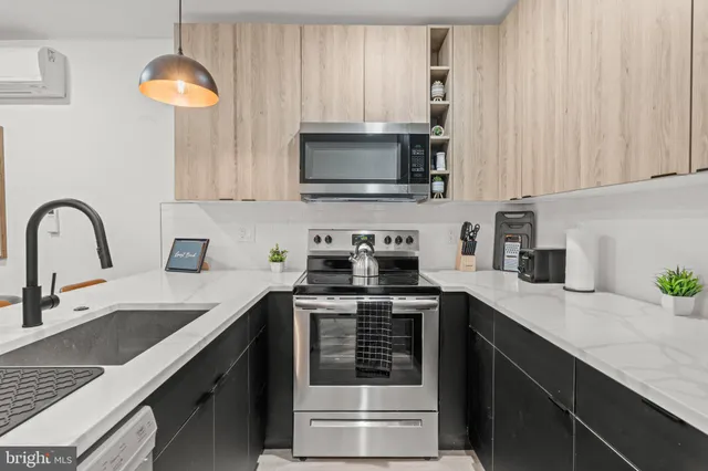 a kitchen with stainless steel appliances a stove a sink a microwave and cabinets