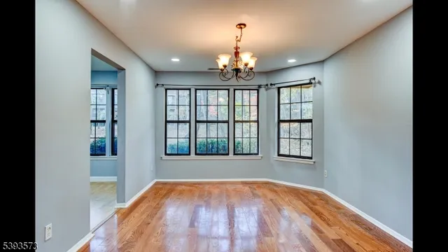 a kitchen with stainless steel appliances granite countertop a stove a refrigerator a sink and dishwasher with wooden floor