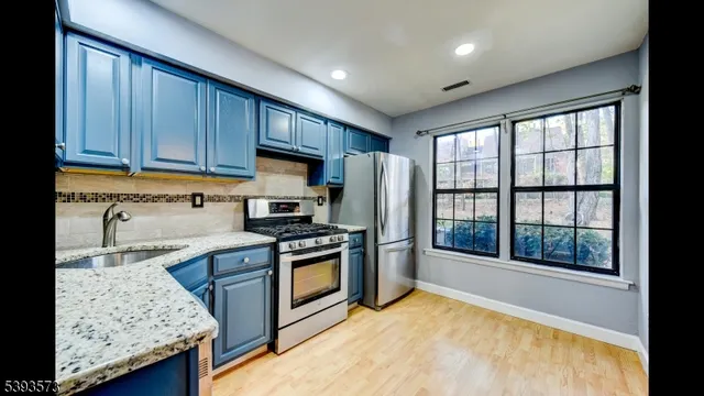 a kitchen with granite countertop wooden cabinets and stainless steel appliances