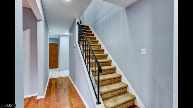 a view of a hallway with wooden floor and stairs
