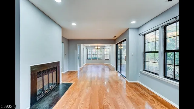 a view of hallway with wooden floor and a fireplace