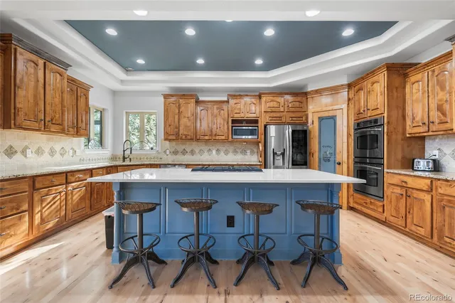 a kitchen with stainless steel appliances granite countertop wooden cabinets a dining table and chairs