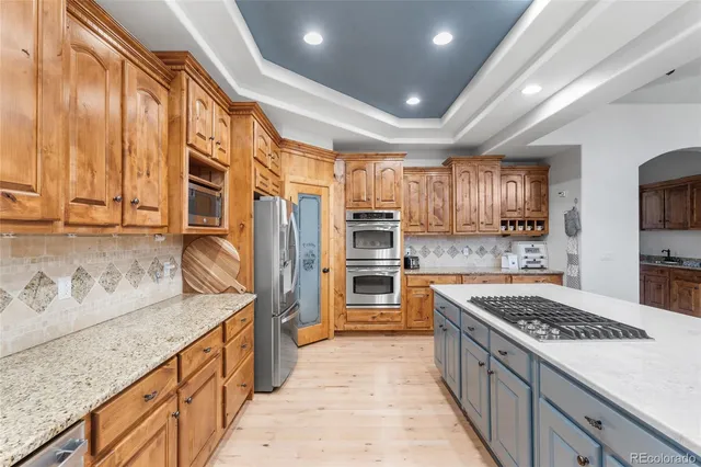 a kitchen with stainless steel appliances granite countertop a stove a sink and a refrigerator