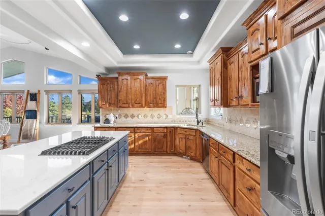 a kitchen with stainless steel appliances granite countertop a sink stove and refrigerator