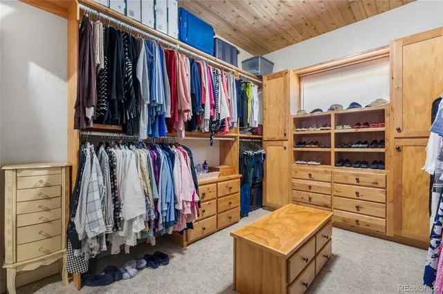 a view of walk in closet with clothes and shoes