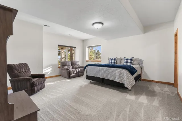 a spacious bedroom with a bed and chair