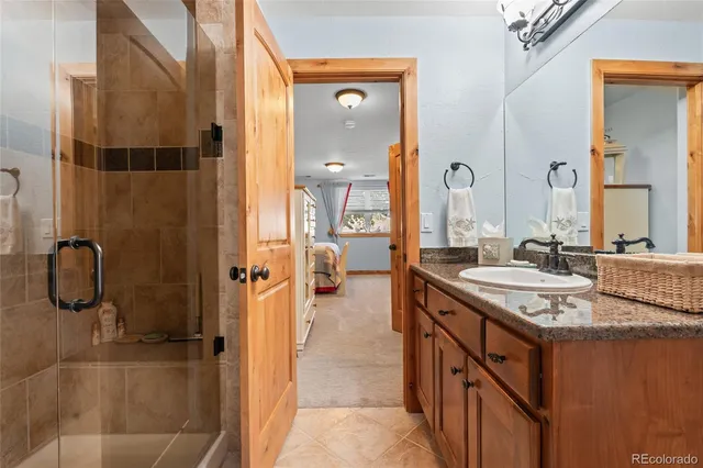 a bathroom with a granite countertop sink a mirror and shower
