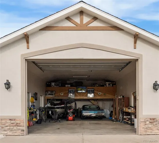 a view of a house with a yard potted plants and a large tree