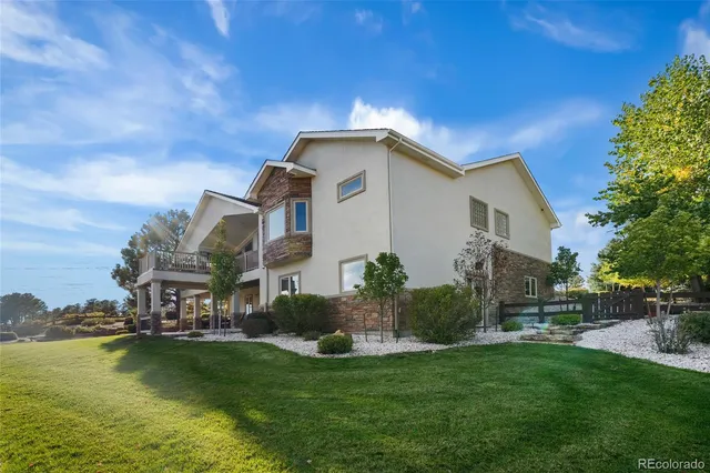 a front view of a house with swimming pool and chairs