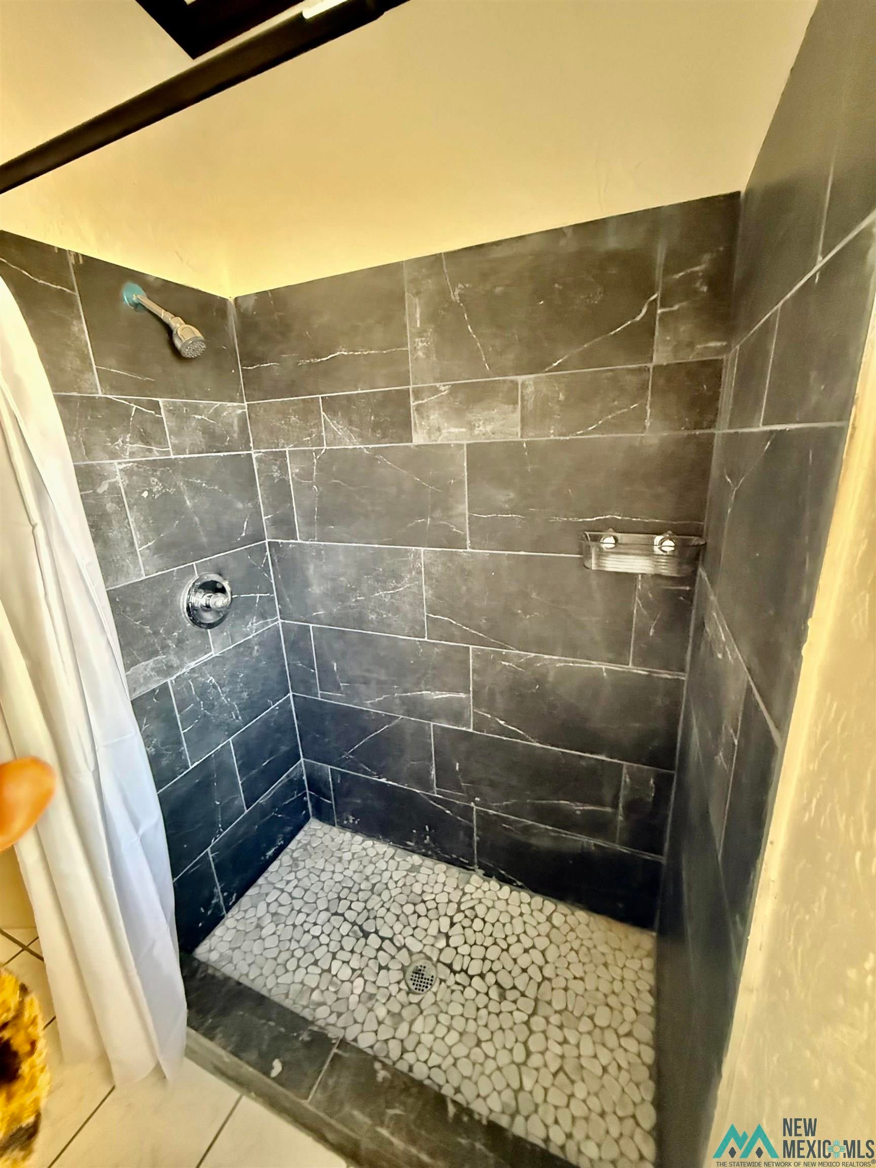 207 Chuckwagon Road Carlsbad, NM 88220 - Photo 8 of 19 Full bath with a stall shower and tile patterned floors