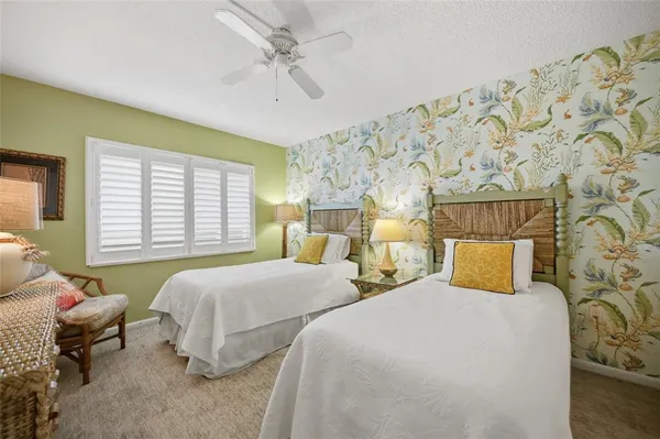 a bedroom with two beds and painting on the wall