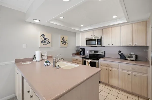 a kitchen with white cabinets sink and stainless steel appliances