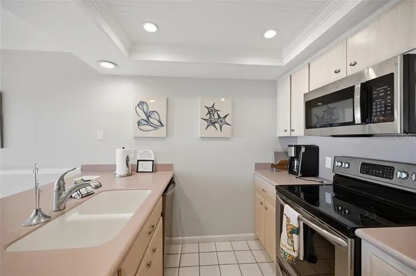a kitchen with granite countertop a sink a stove top oven and cabinetry