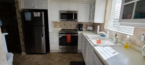 a kitchen with stainless steel appliances granite countertop a refrigerator and a stove top oven