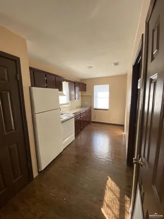 a view of kitchen with refrigerator and wooden floor