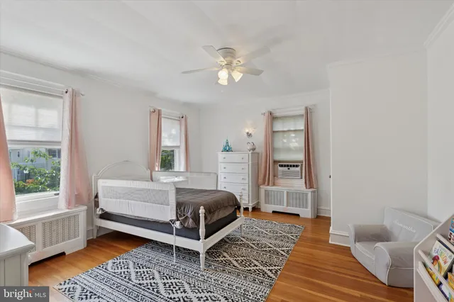a bedroom with a bed wooden floor and a window