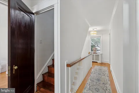 a view of a hallway with wooden floor and staircase