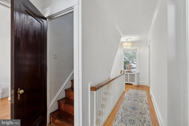 a view of a hallway with wooden floor and staircase