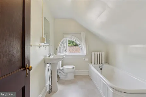 a bathroom with a bathtub and a window