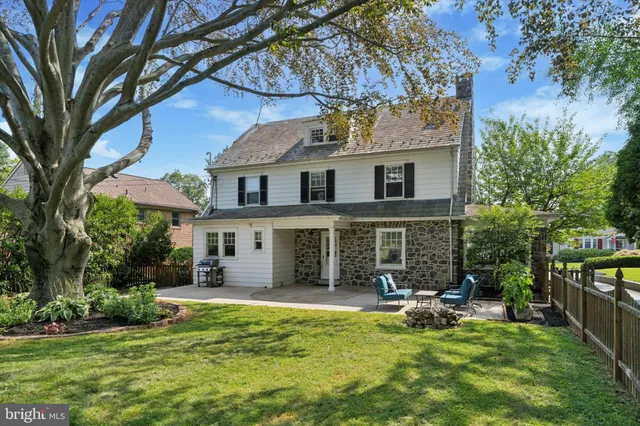 a backyard of a house with table and chairs and potted plants