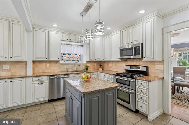 a kitchen with kitchen island granite countertop a sink counter top space appliances and cabinets